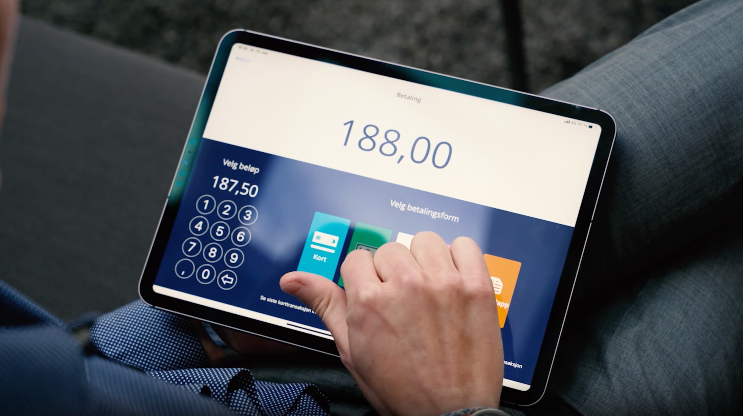 En hånd som trykker på et betalingsvalg på en Shoplabs iPad-kasseskjerm